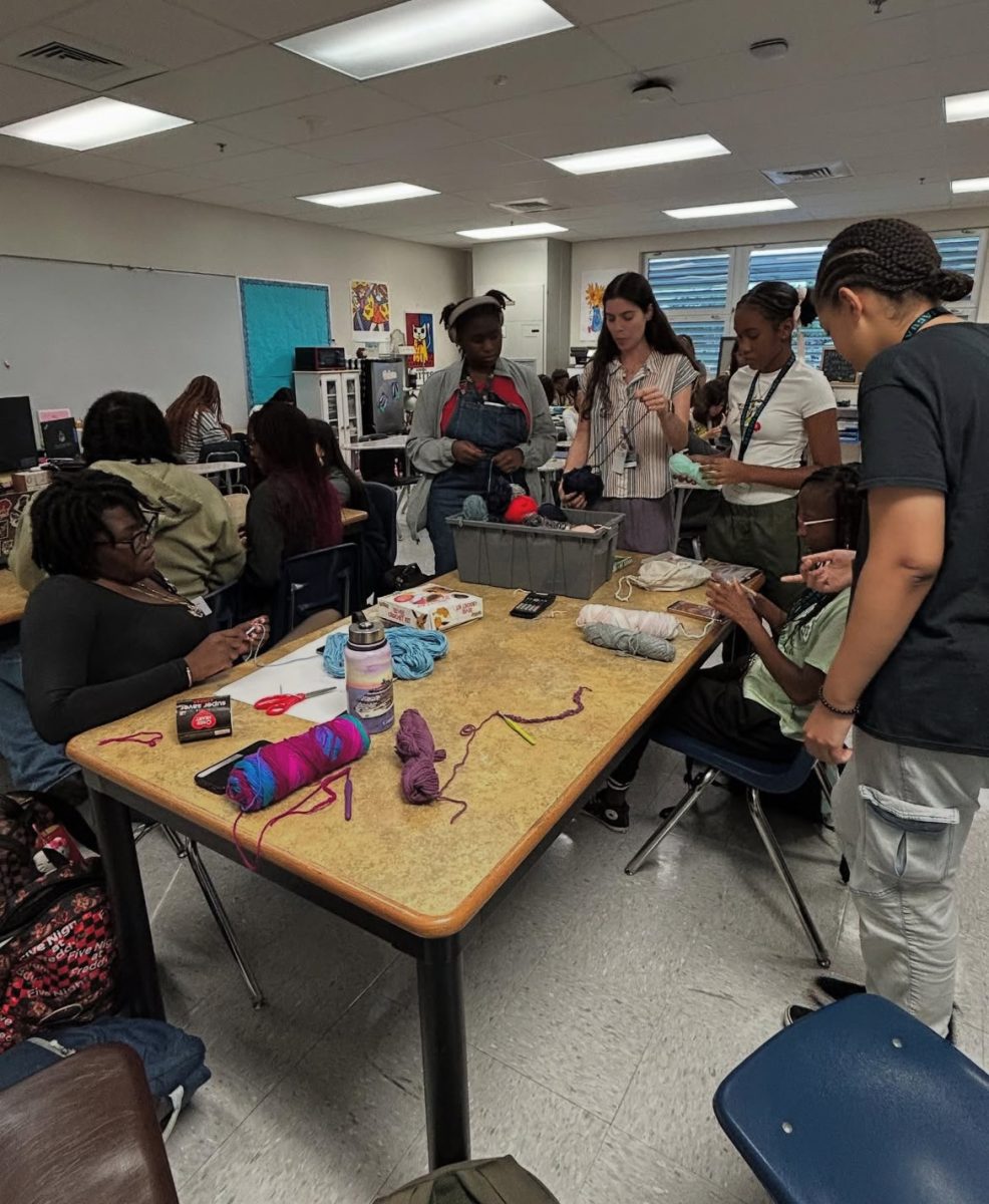 Students learning how to crochet in Ms. Ofri's crochet club!