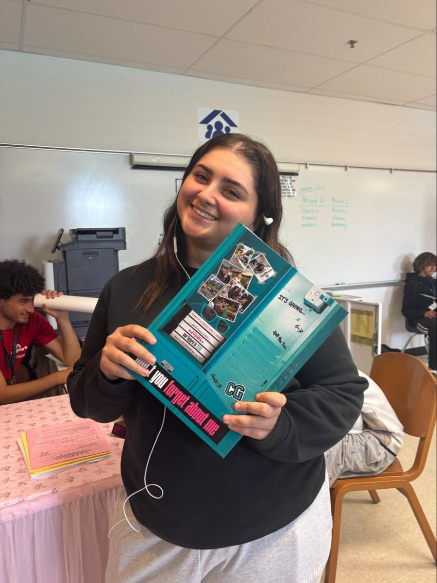 Senior Yasmeen Atallah holding the 2025-2026 Coral Glades Highschool yearbook. 
